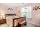 Charming bedroom with a wooden bed frame, bedside table, and soft pink walls at 4726 Southern Trail, Myrtle Beach, SC 29579