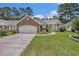 Daytime view of a lovely single-story home with manicured lawn, brick accents, and attached two-car garage at 4726 Southern Trail, Myrtle Beach, SC 29579