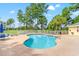 Inviting community pool surrounded by trees and a fence with ample seating for residents at 4865 Luster Leaf Circle # 402, Myrtle Beach, SC 29577