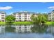 Condo buildings with a tranquil pond view reflecting the buildings under a sunny, blue sky at 4865 Luster Leaf Circle # 402, Myrtle Beach, SC 29577