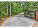 Gated driveway leading to brick home surrounded by lush landscaping and mature trees at 487 Trestle Way, Conway, SC 29526