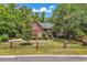 Beautiful red brick home showcasing a well-maintained lawn and secure gated entrance at 487 Trestle Way, Conway, SC 29526