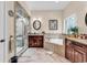 Main bathroom featuring dual vanities with soaking tub and glass-enclosed shower on top of tiled floor at 487 Trestle Way, Conway, SC 29526