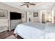 Bright main bedroom with wood floors, tray ceiling, large TV, and view into main bathroom and closet at 487 Trestle Way, Conway, SC 29526