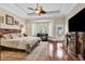 Comfortable main bedroom featuring hardwood floors, trey ceiling, a ceiling fan, sitting area, and a television at 487 Trestle Way, Conway, SC 29526