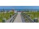 A beach access wooden walkway leading to a sandy beach with blue umbrellas and ocean views at 503 20Th Ave. N # 9D, North Myrtle Beach, SC 29582