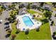 Aerial view of a community pool with lounge chairs, umbrellas, and a playground nearby at 503 20Th Ave. N # 9D, North Myrtle Beach, SC 29582