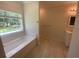 A bright bathroom with a window view, bathtub, and stand-up shower at 5310 Pauley Swamp Rd., Conway, SC 29527
