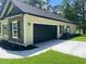 Attached garage with a black garage door and stone details at 5310 Pauley Swamp Rd., Conway, SC 29527