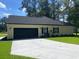 Side view of the garage showing a black garage door and exterior finishes at 5310 Pauley Swamp Rd., Conway, SC 29527