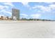 Wide sandy beach, blue skies, and high-rise condo buildings near by at 5523 N Ocean Blvd. # 1410, Myrtle Beach, SC 29577