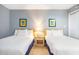 Bright bedroom with two beds, blue accents, and a nightstand between them at 5523 N Ocean Blvd. # 1410, Myrtle Beach, SC 29577