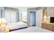 Bedroom featuring two beds, open bathroom door, and a dresser with a lamp at 5523 N Ocean Blvd. # 1410, Myrtle Beach, SC 29577