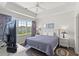 Comfortable bedroom featuring tray ceilings, a ceiling fan, and large windows with neighborhood views at 5801 Oyster Catcher Dr. # 431, North Myrtle Beach, SC 29582