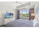 Cozy bedroom with a ceiling fan, tray ceiling, and a large window overlooking the neighborhood at 5801 Oyster Catcher Dr. # 431, North Myrtle Beach, SC 29582