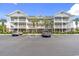 Beautiful condo building with multiple levels, palm trees, ample parking, and manicured landscaping at 5801 Oyster Catcher Dr. # 431, North Myrtle Beach, SC 29582