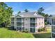 Exterior view of a three-story condo building with screened patios and lush greenery at 605 Waterway Village Blvd. # 31A, Myrtle Beach, SC 29579