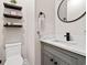 Neat bathroom with a sleek vanity, dark fixtures, and decorative floating shelves at 609 Mccown Dr., Conway, SC 29526