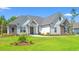 Beautiful single-story home with stone and white siding, complemented by a lush green lawn at 609 Mccown Dr., Conway, SC 29526