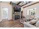 Cozy living room features a stone fireplace, wood beam ceiling accents, and hardwood flooring at 609 Mccown Dr., Conway, SC 29526
