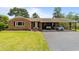 Charming brick home featuring a well-maintained lawn, a covered two car carport, and classic architectural details at 6204 Sancindy Ln., Myrtle Beach, SC 29572