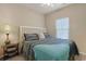 Cozy bedroom features a bed with patterned bedding, side table with lamp, and window at 6253 Catalina Dr. # 1711, North Myrtle Beach, SC 29582