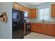 Well-equipped kitchen boasts black appliances, granite countertops, and wooden cabinetry at 6253 Catalina Dr. # 1711, North Myrtle Beach, SC 29582