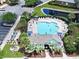 Aerial view of community pool and clubhouse, featuring lounge chairs, picnic tables, landscaping, and building at 6253 Catalina Dr. # 1711, North Myrtle Beach, SC 29582
