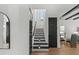 Elegant entryway featuring a staircase with modern lighting and dark accents, complemented by sleek black doors at 6706 Ocean Breeze Loop, Myrtle Beach, SC 29572