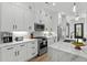 Well-lit kitchen features white cabinets, stainless steel appliances, and a large island with marble countertops at 6706 Ocean Breeze Loop, Myrtle Beach, SC 29572