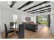 Open-concept living room boasts high ceilings with dark beams, modern lighting, and access to a patio at 6706 Ocean Breeze Loop, Myrtle Beach, SC 29572