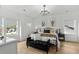 Bright main bedroom featuring large windows, a decorative chandelier, and a cozy sitting area at 6706 Ocean Breeze Loop, Myrtle Beach, SC 29572