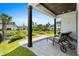 Covered patio features comfortable lounge chairs with a serene view of the landscaped backyard and water feature at 6706 Ocean Breeze Loop, Myrtle Beach, SC 29572