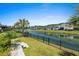 Backyard with wrought iron fence looks out over the community pond with fountains, with neighboring houses in the background at 6706 Ocean Breeze Loop, Myrtle Beach, SC 29572