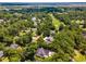 An aerial view highlights a residential area with mature trees and a nearby golf course at 77 Capt Anthony White Ln., Georgetown, SC 29440