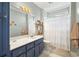 Well-lit bathroom features a sink with blue vanity, toilet, and bathtub with shower at 77 Capt Anthony White Ln., Georgetown, SC 29440