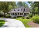 Inviting home featuring a classic design with a front porch and lush greenery surrounding the property at 77 Capt Anthony White Ln., Georgetown, SC 29440
