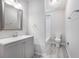 A well-lit bathroom with a gray vanity, modern fixtures, a framed mirror, and a toilet with a shower at 800 Egret Circle # 53, Little River, SC 29566