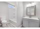 A well-lit bathroom with a gray vanity, modern fixtures, a framed mirror, and a combined toilet/shower at 800 Egret Circle # 53, Little River, SC 29566