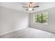 A bright bedroom featuring neutral walls, a ceiling fan, and a large window offering serene outdoor views at 800 Egret Circle # 53, Little River, SC 29566