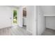 Cozy entryway with gray wood floors, white walls, natural light, and laundry room visible through the doorway at 800 Egret Circle # 53, Little River, SC 29566