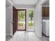Bright entryway featuring a storm door, wood-look flooring and views of the laundry area at 800 Egret Circle # 53, Little River, SC 29566