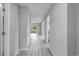 Hallway featuring gray wood-look flooring, white walls, and natural light streaming into the living spaces at 800 Egret Circle # 53, Little River, SC 29566