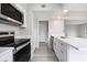 Bright kitchen with stainless steel appliances, white cabinetry, quartz countertops, and gray wood-look flooring at 800 Egret Circle # 53, Little River, SC 29566