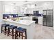 Well-lit kitchen featuring white cabinets, a breakfast bar with blue stools, and stainless steel appliances at 867 Cardinal Pl., North Myrtle Beach, SC 29582