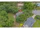 Aerial view of a home showcasing the roof, landscaping, and surrounding trees in a lush neighborhood at 100 Brookgreen Trace Pl., Pawleys Island, SC 29585