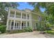 Rear view of a two-story home with a spacious porch, columns, and a basketball hoop at 100 Brookgreen Trace Pl., Pawleys Island, SC 29585