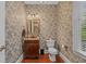 Charming half bathroom with vintage wallpaper, wooden floors, and a classic vanity at 100 Brookgreen Trace Pl., Pawleys Island, SC 29585