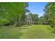 Beautiful two-story home with a lush green lawn and mature trees providing shade and privacy at 100 Brookgreen Trace Pl., Pawleys Island, SC 29585