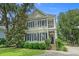 Charming two-story home with black shutters, a small balcony, and manicured landscaping at 100 Brookgreen Trace Pl., Pawleys Island, SC 29585